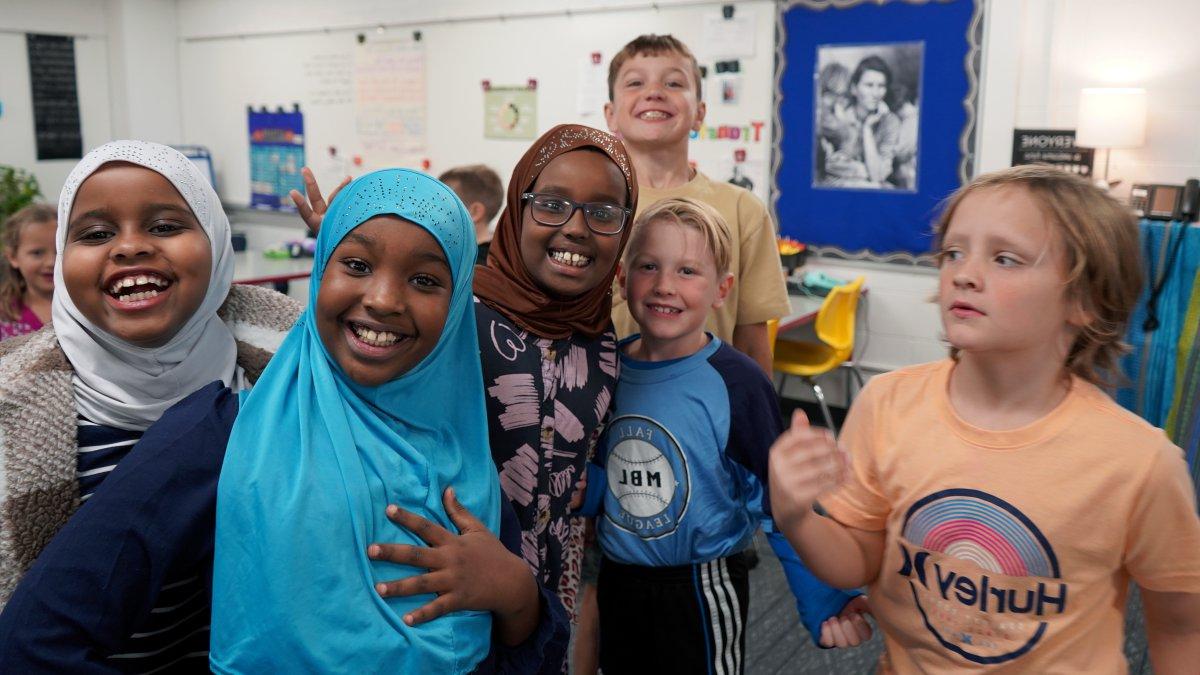 six students smiling in classroom