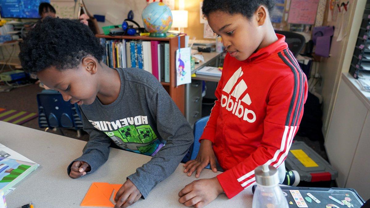 two boys working on a tangram